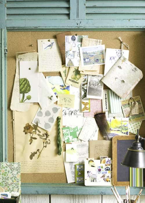 framed cork pin board with postcards and pictures for organizing